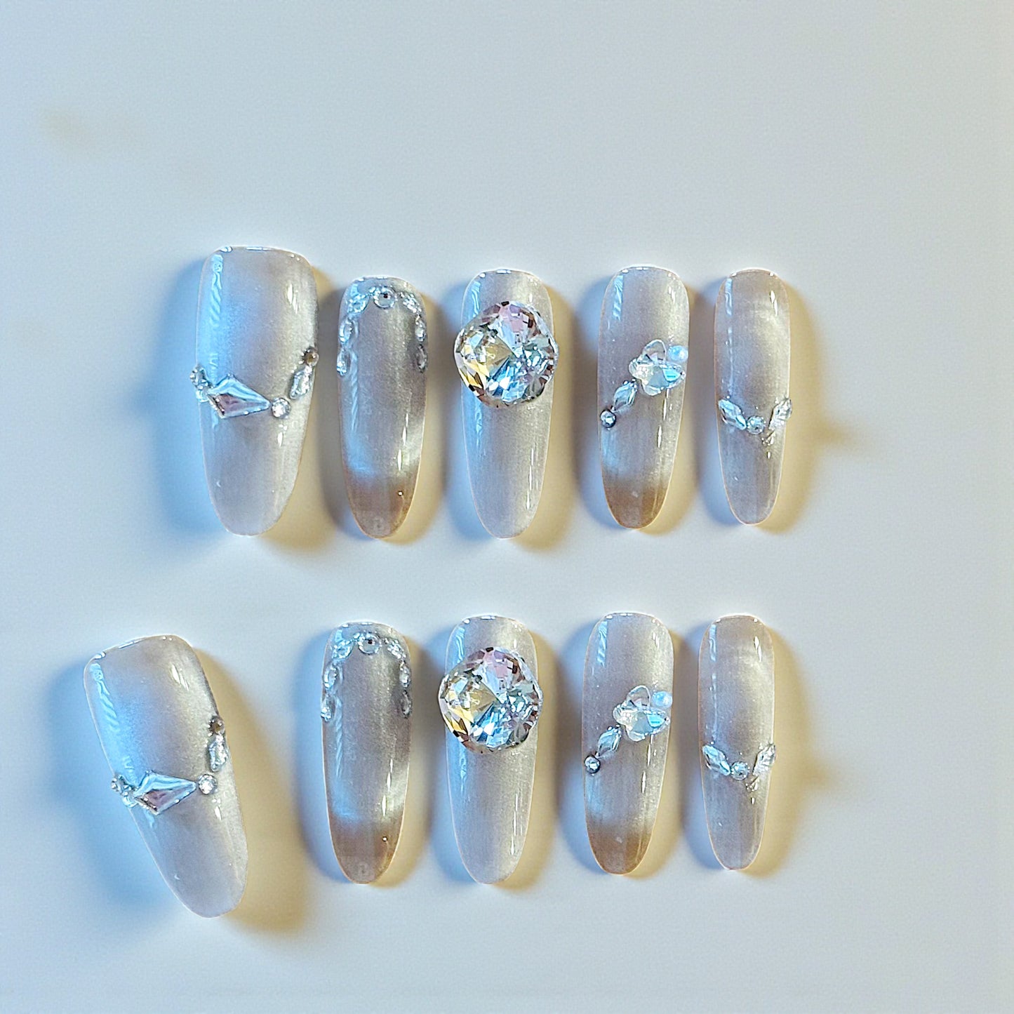 Decorative nails with crystals and rhinestones on a light background