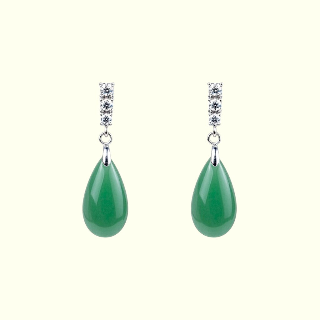 Pair of green teardrop earrings with silver and gemstone details on a white background