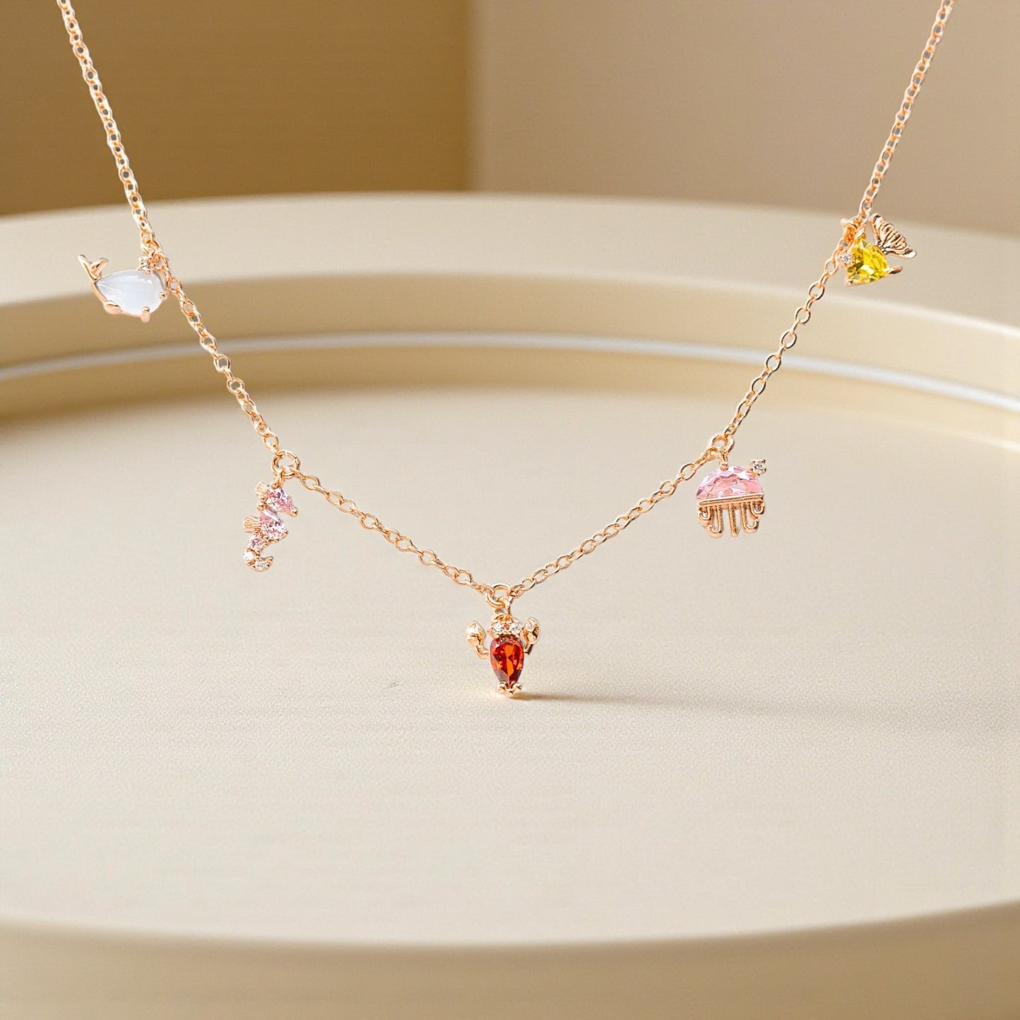 Delicate gold necklace with colorful gemstones on a beige background