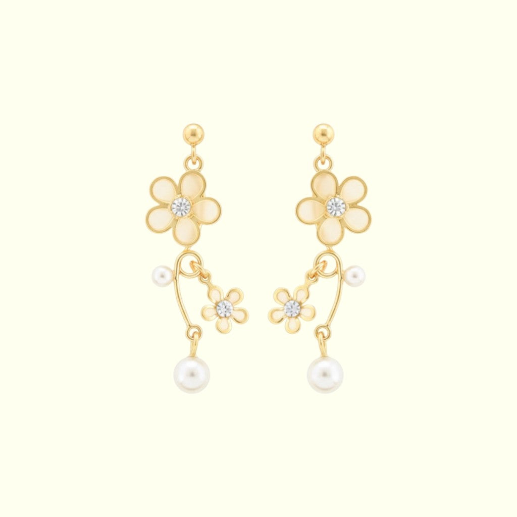 Gold flower-shaped earrings with pearls on a white background