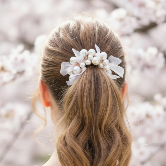 Woman with a ponytail adorned with a decorative hair clip against a blurred floral background