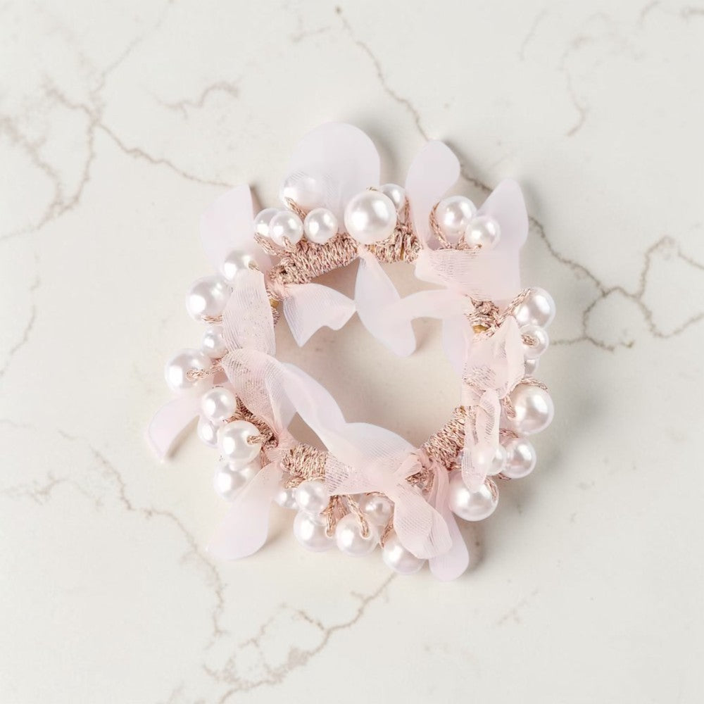 Decorative headband with pearls and ribbons on a marble surface