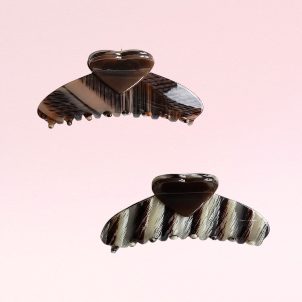 Two striped hair clips on a pink background