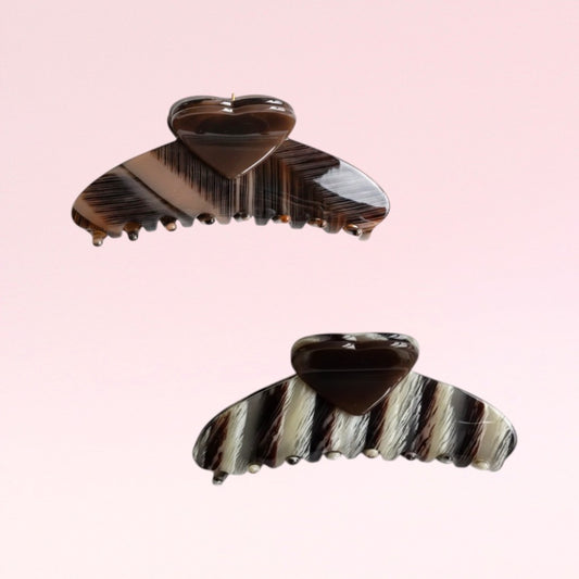 Two striped hair clips on a pink background