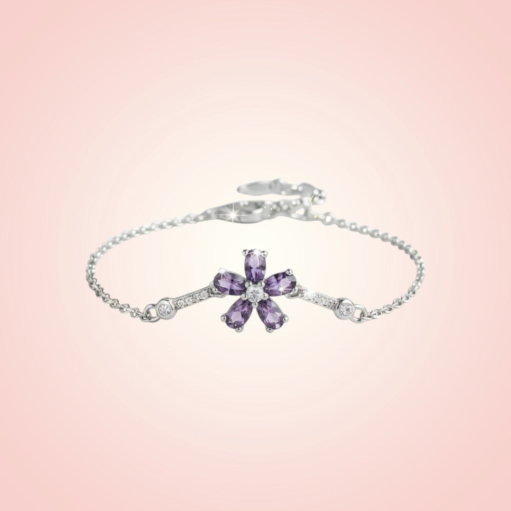 Silver bracelet with a purple flower-shaped gemstone on a pink background