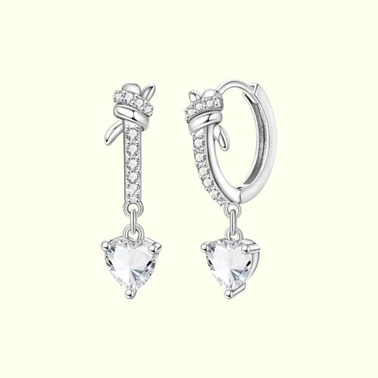 Silver earrings with heart-shaped crystals on a white background