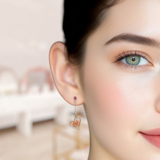 Close-up of a woman wearing a heart-shaped earring with a purple gemstone.