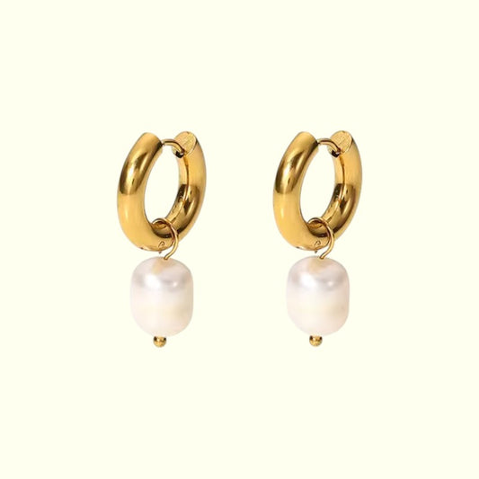 Gold hoop earrings with white pearls on a white background