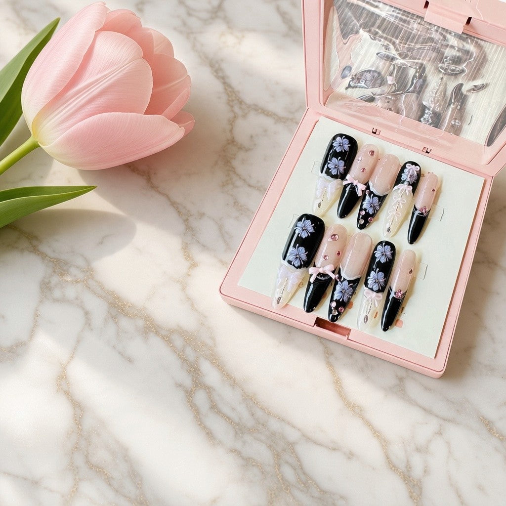 Handmade black and nude stiletto press-on nails with delicate lavender floral nail art, 3D bows, and sparkling rhinestone accents by Bows and Knots Co.