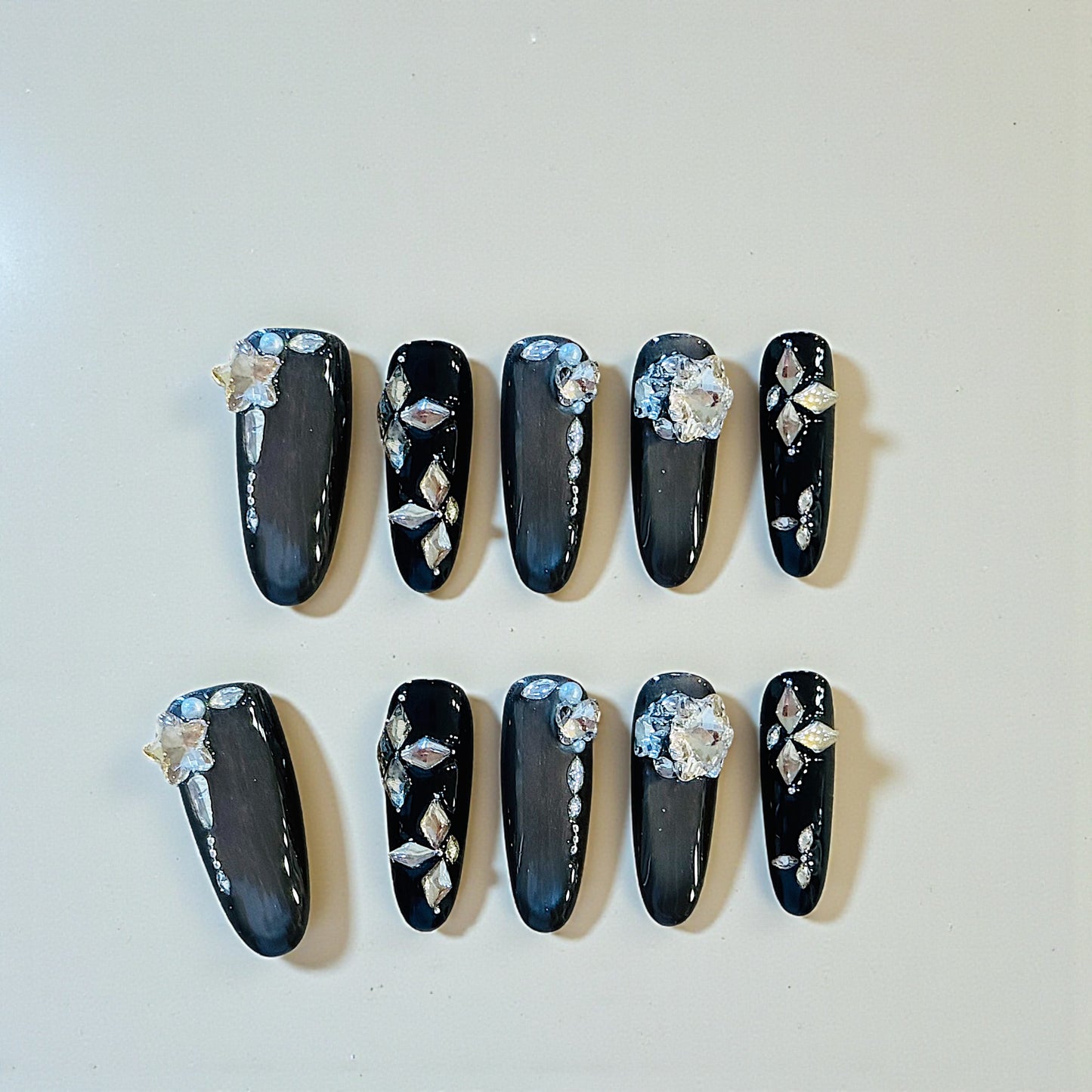 Black nail art with floral decorations on a white background