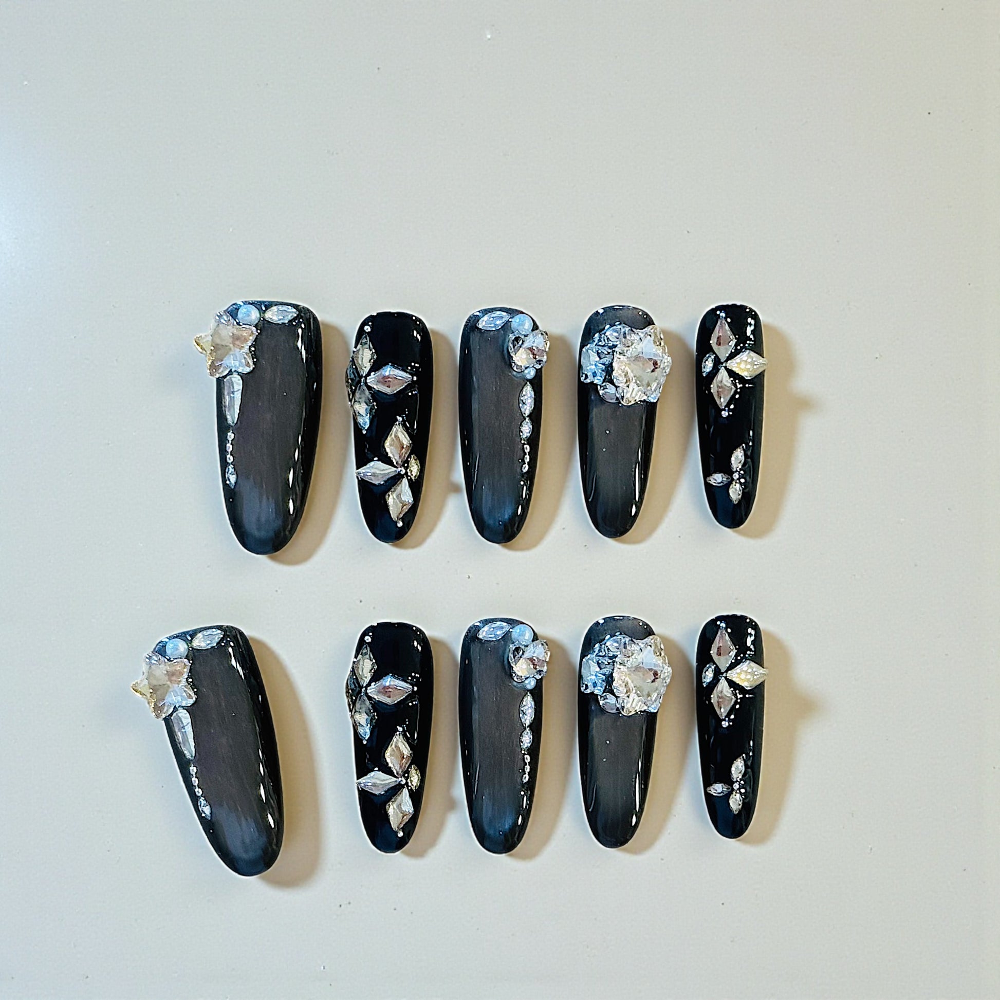 Black nail art with floral decorations on a white background