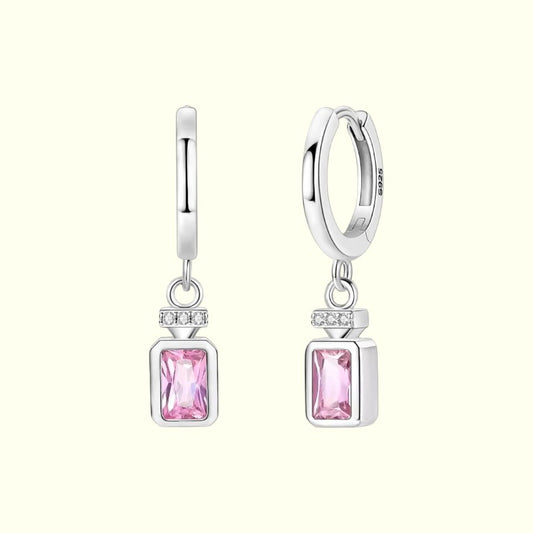 Silver hoop earrings with pink gemstones on a white background