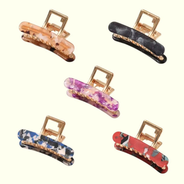 Set of colorful hair clips with gold hardware on a white background