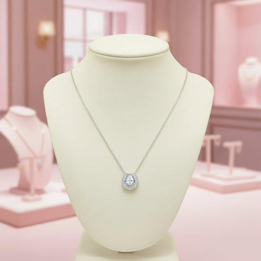 Necklace with a diamond pendant on a mannequin bust in a pink jewelry store setting