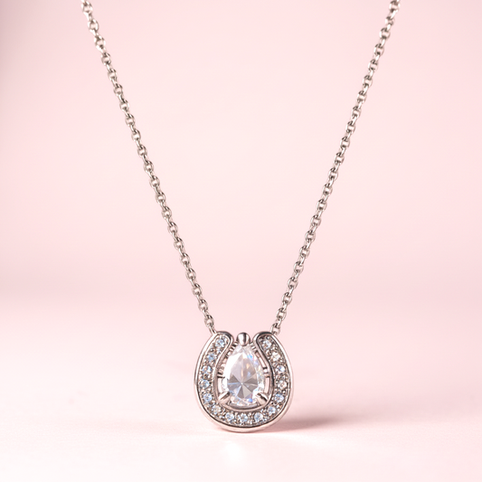 Necklace with a horseshoe-shaped pendant on a pink background