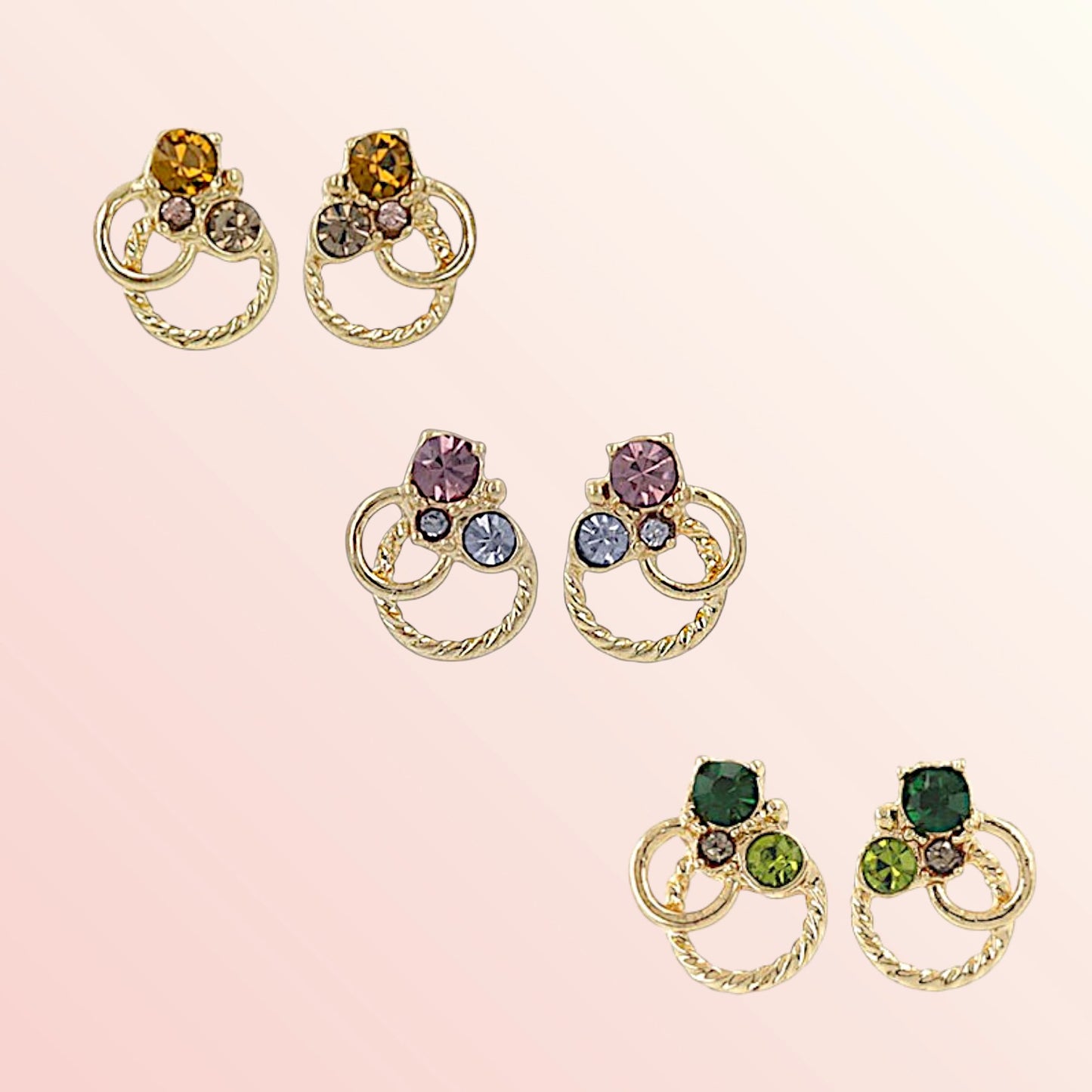 Pair of gold earrings with multicolored gemstones on a pink background