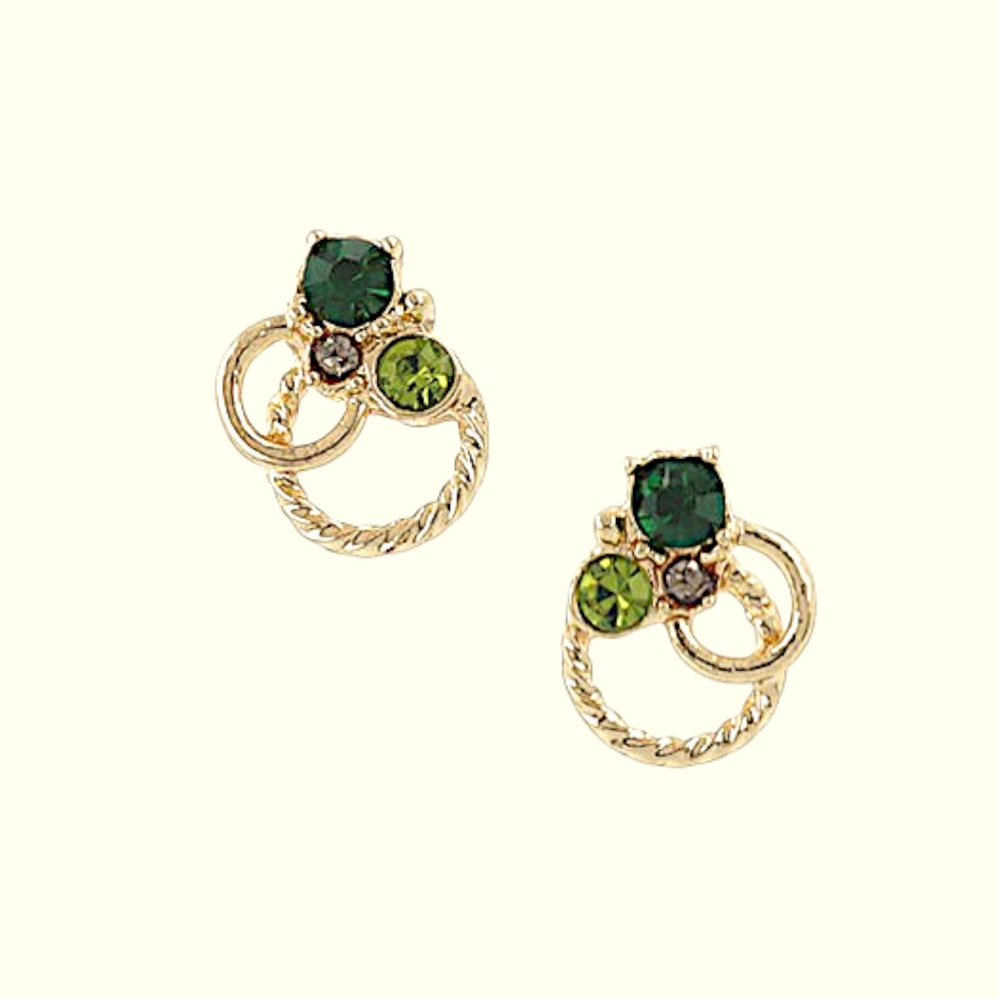 Gold earrings with green gemstones on a white background