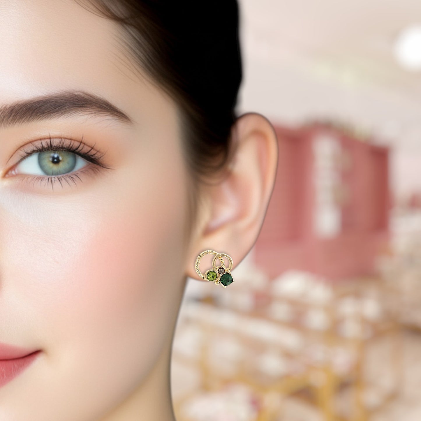 Close-up of a woman wearing a gold earring with green stones.