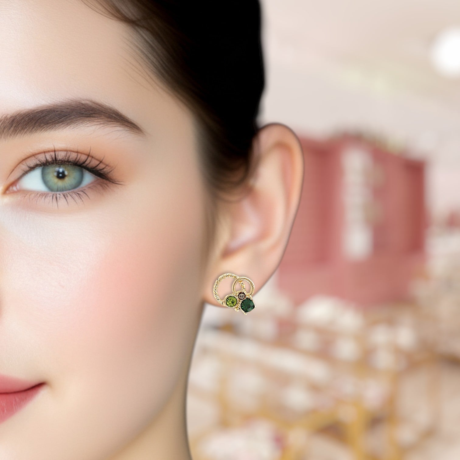 Close-up of a woman wearing a gold earring with green stones.