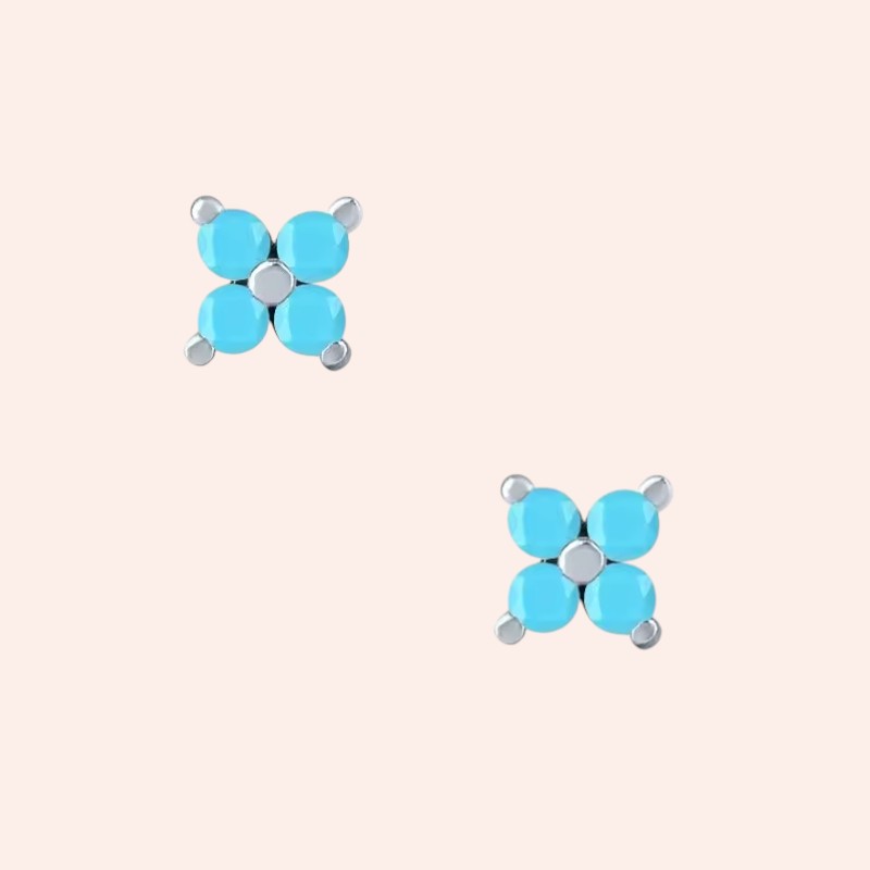 Pair of turquoise butterfly-shaped earrings on a light pink background
