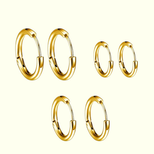 Set of gold hoop earrings on a white background