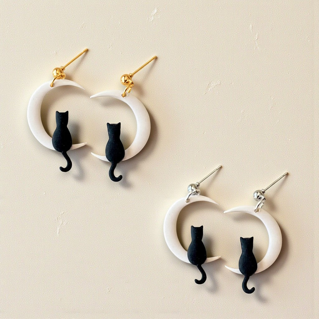 Cat-shaped earrings on a beige background