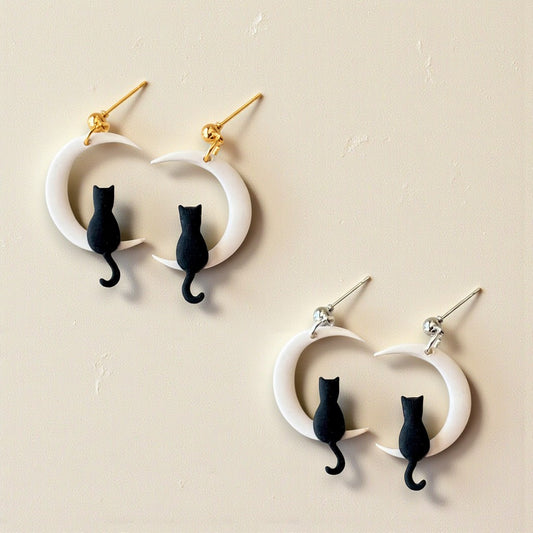 Cat-shaped earrings on a beige background