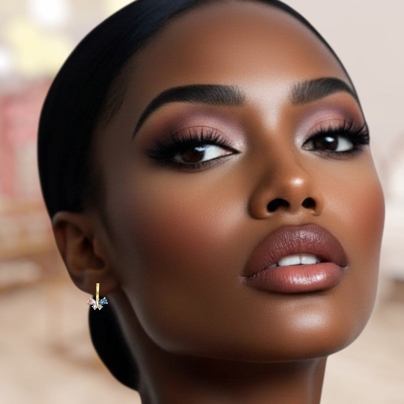 Close-up of a woman's face with makeup and earrings, blurred background