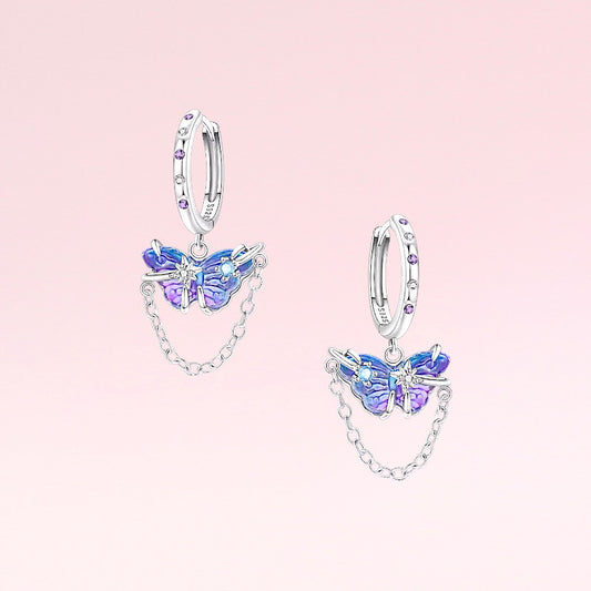 Butterfly-shaped earrings on a pink background