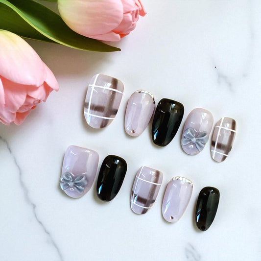 Pastel nail art with floral designs on a white surface with tulips.