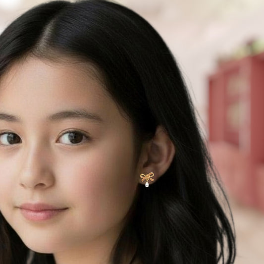 Close-up of a woman wearing a gold butterfly earring with a blurred background