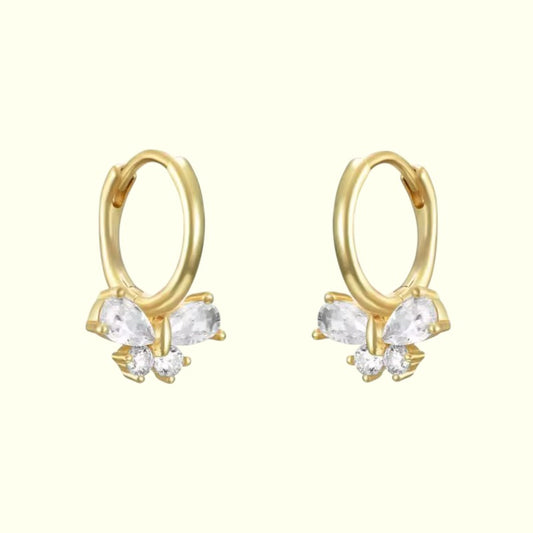 Gold butterfly hoop earrings with clear gemstones on a white background
