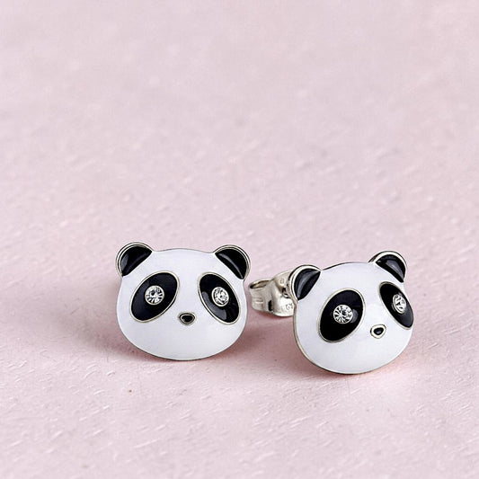 Panda-shaped earrings with black details on a pink background