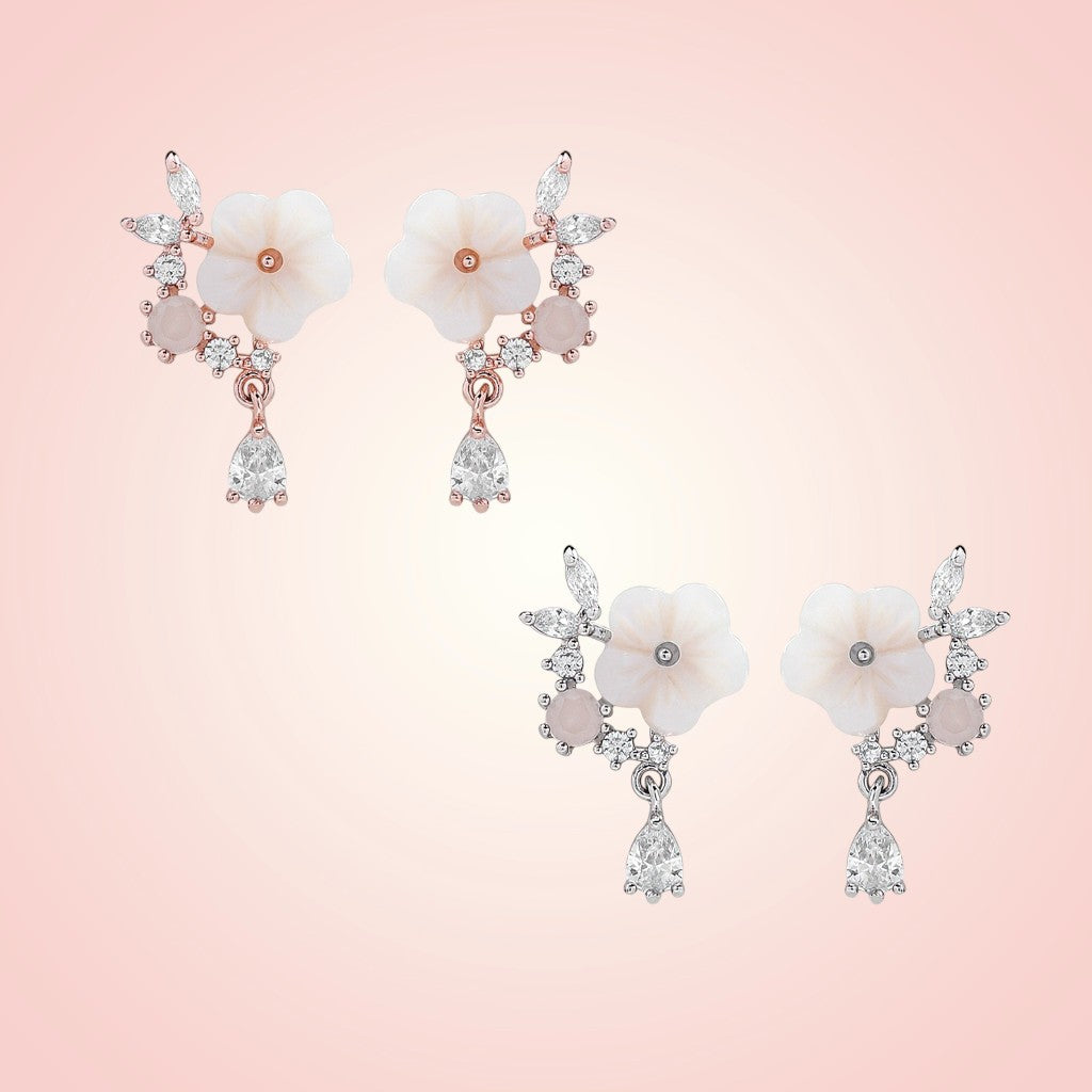 Floral earrings with gemstones on a pink background