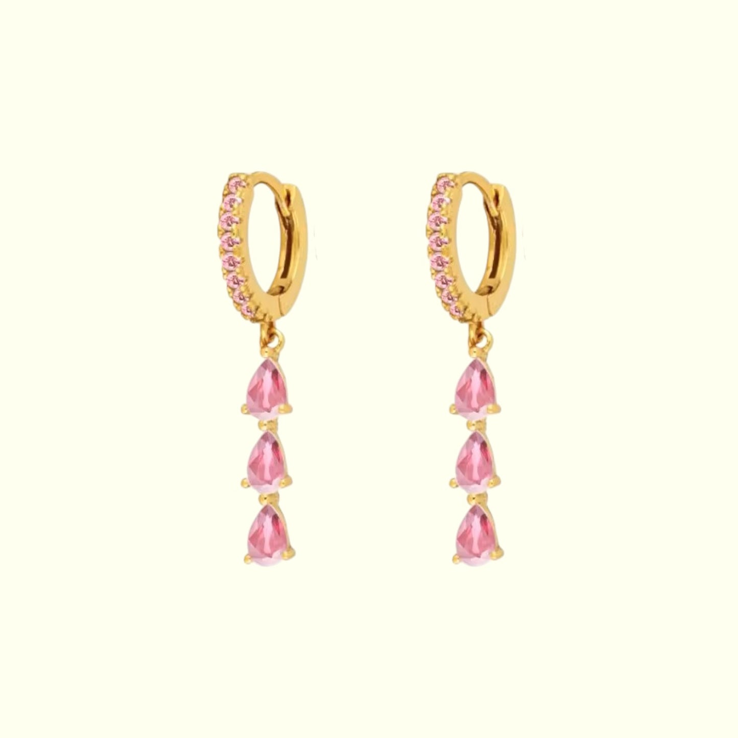Gold hoop earrings with pink teardrop-shaped stones on a white background