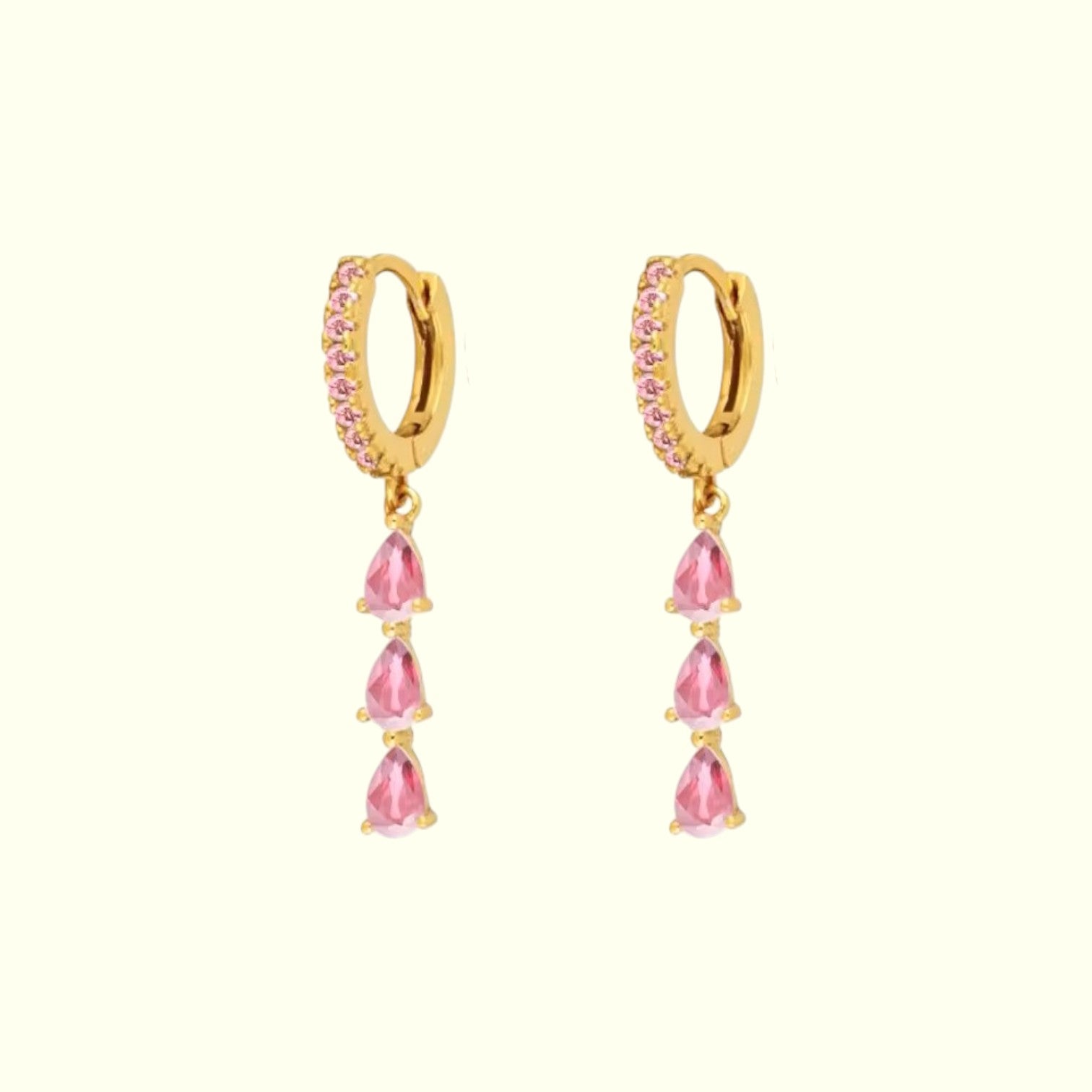 Gold hoop earrings with pink teardrop-shaped stones on a white background