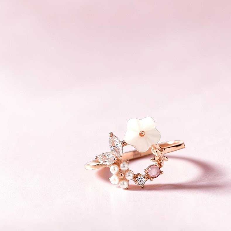Delicate ring with pearls and gemstones on a pink background