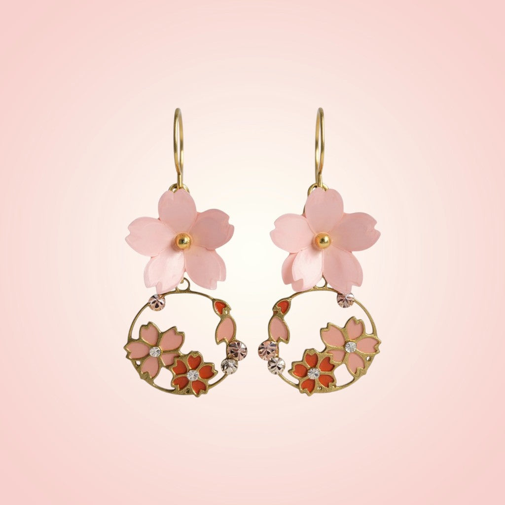 Floral earrings with pink and orange flowers on a pink background