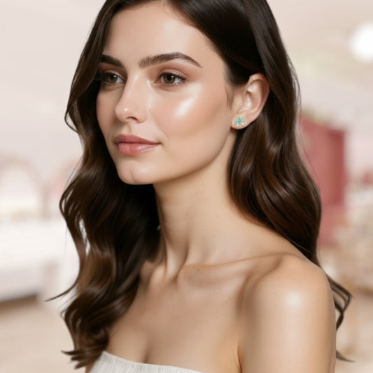 Woman with long, wavy hair wearing a bows and knots co flower stud against a blurred indoor background