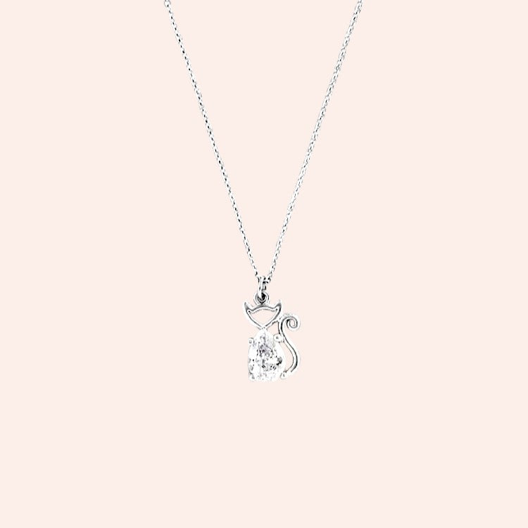 Silver necklace with a cat-shaped pendant on a light pink background