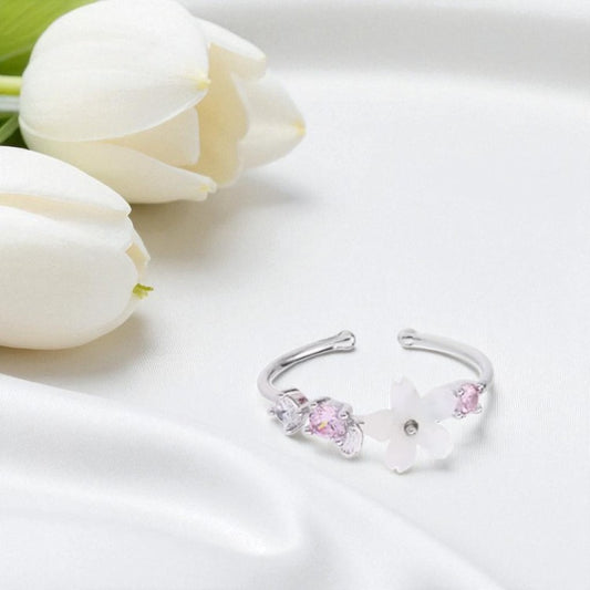 Silver bracelet with pink stones on a white surface with white tulips