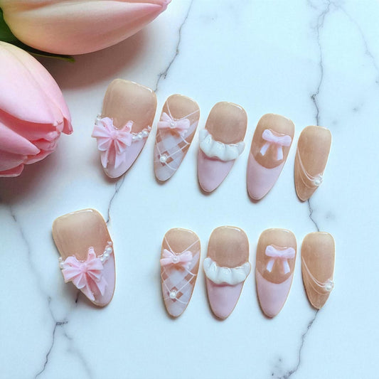 Decorative nail art with pink and beige designs on a marble surface with tulips.
