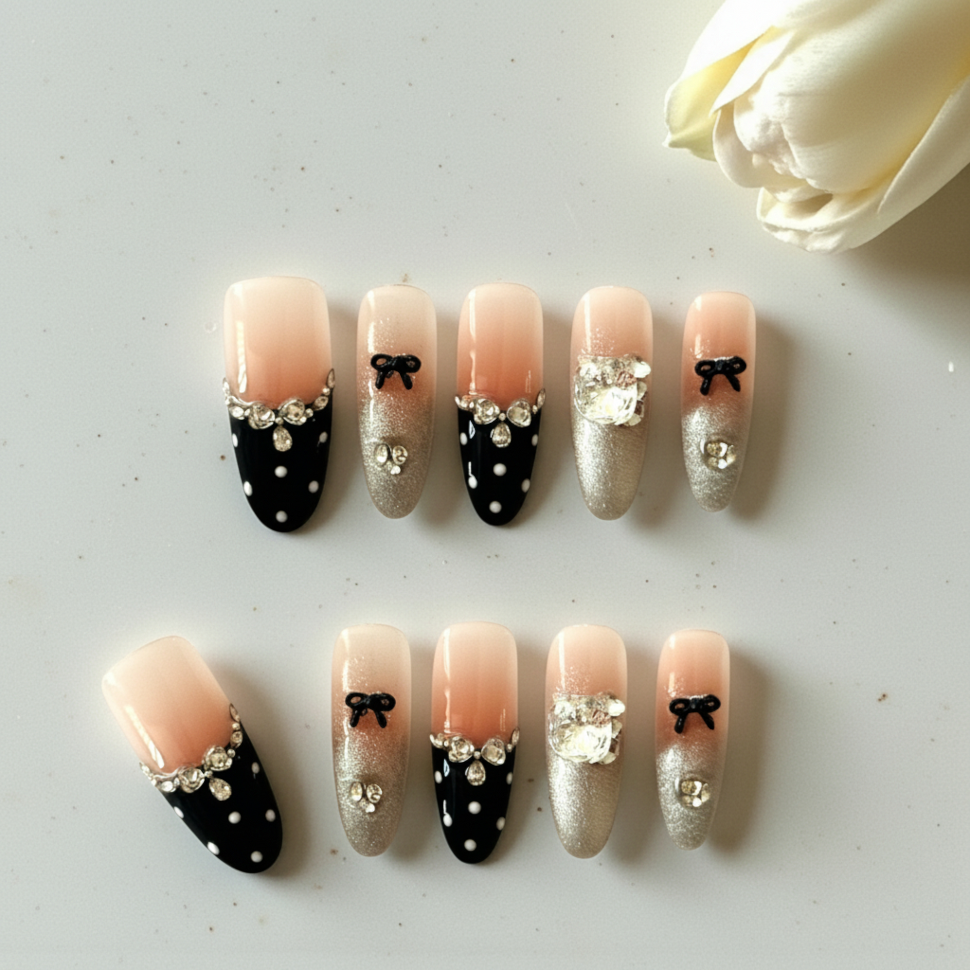 Set of decorative nails with bows and rhinestones on a light background