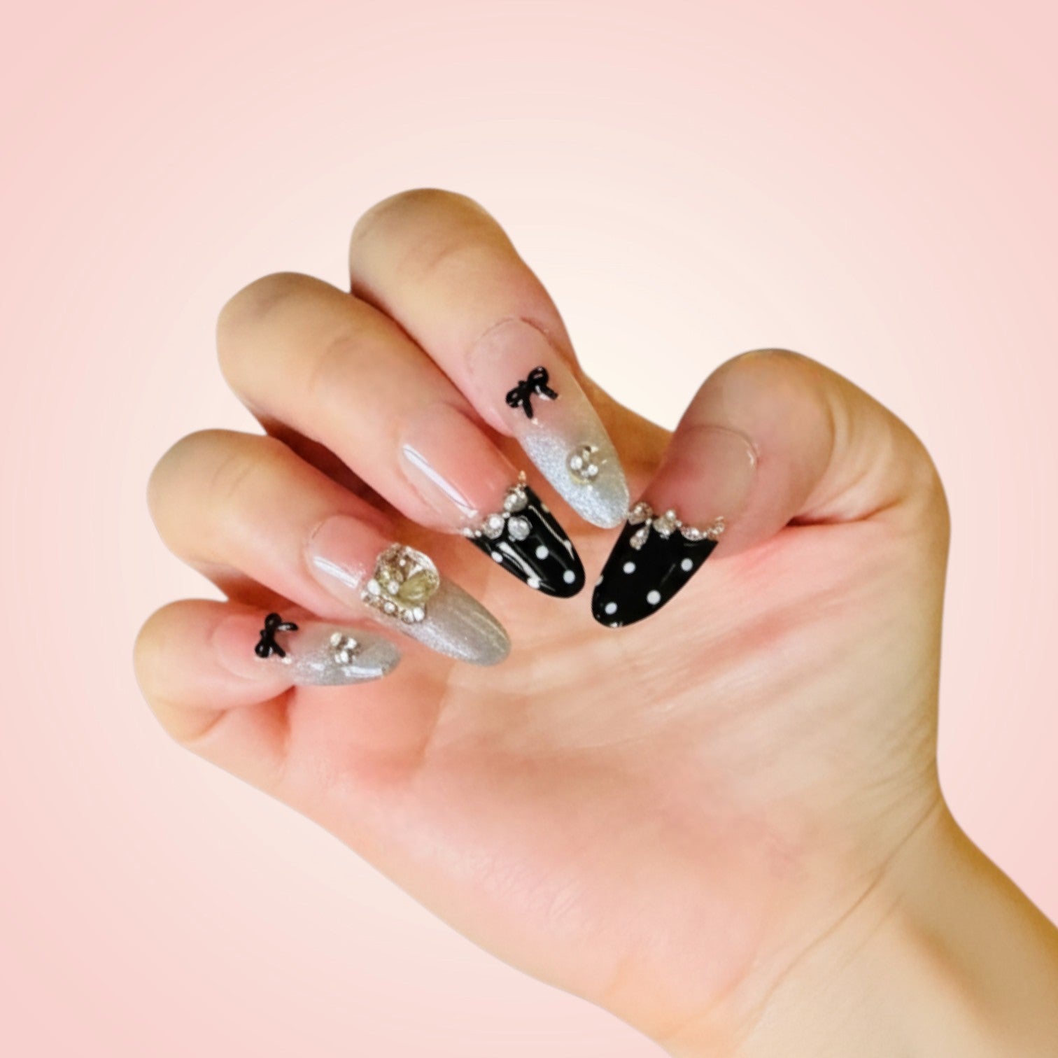 Hand with intricately designed nails on a pink background