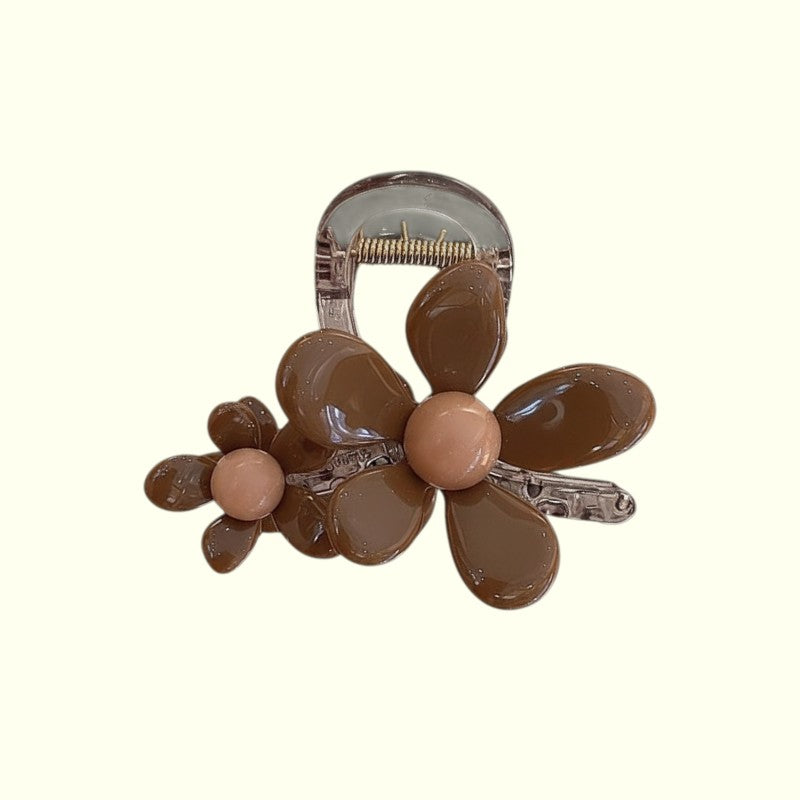 Brown flower-shaped hair clip on a white background