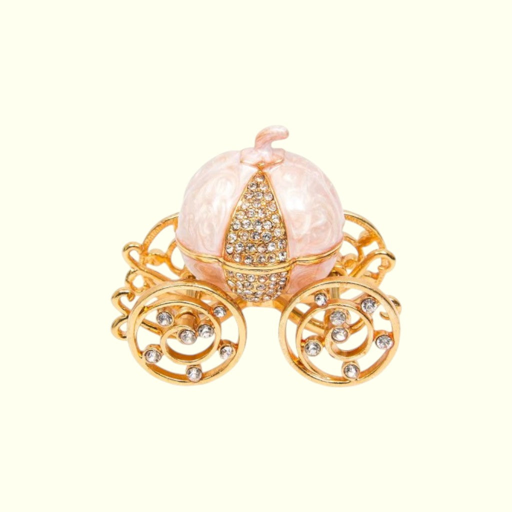Decorative pumpkin carriage with gold accents on a white background