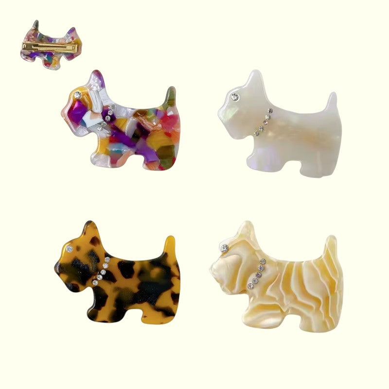 Set of four dog-shaped brooches with different color patterns on a white background