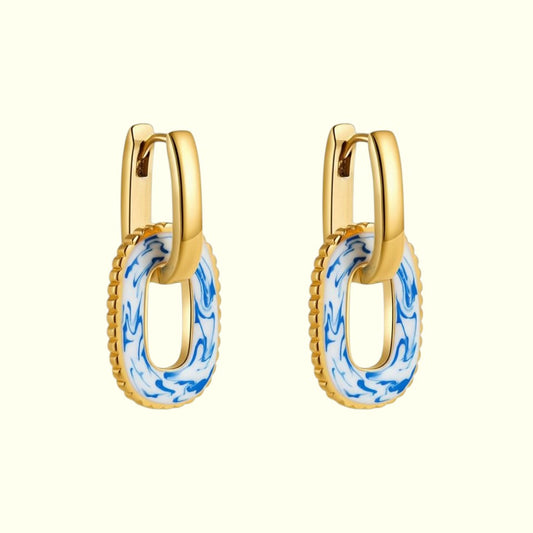 Gold hoop earrings with blue and white pattern on a white background