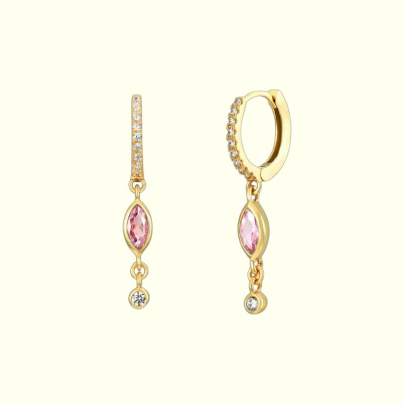 Gold earrings with pink gemstones on a white background