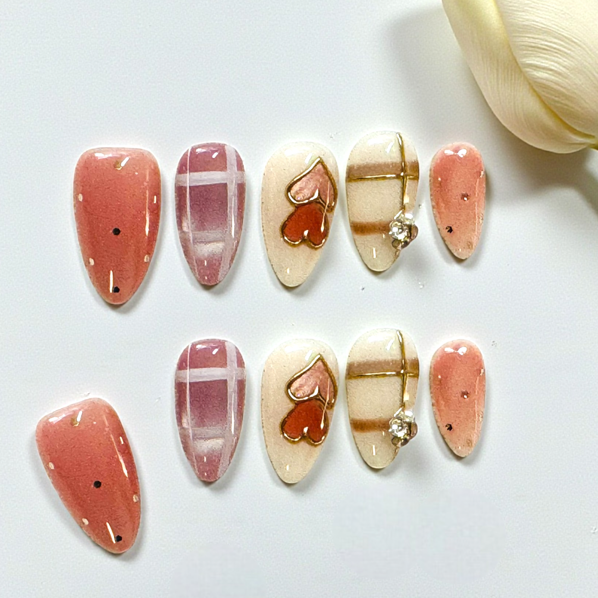 Set of decorative stones with heart and stripe patterns on a white surface